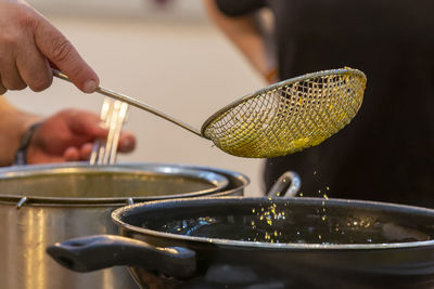 Cook preparing and picking up freshly fried product with the frying pan paddle,