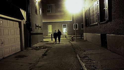 Rear view of silhouette people walking on street at night