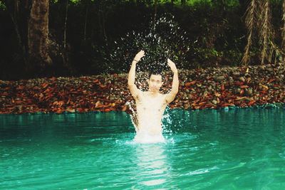 Man surfing in swimming pool against trees