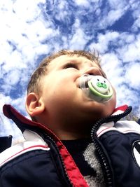 Close-up of boy wearing sunglasses against sky