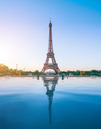 Reflection of eiffel tower in river against sky