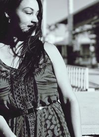 Mid adult woman looking away while standing outdoors