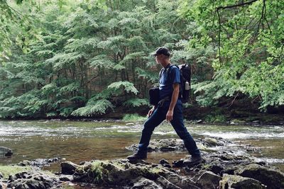 Full length of woman on riverbank in forest
