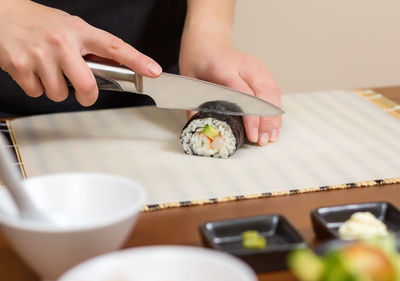 Midsection of woman holding sushi