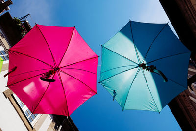 Low angle view of umbrellas against sky during sunny day