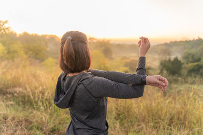 Rear view of woman standing on field