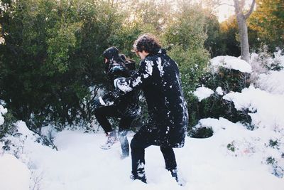 Full length of man on snow covered tree