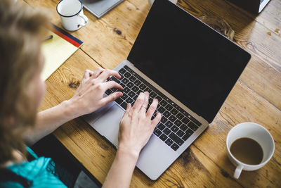 High angle view of female it expert coding in laptop at desk