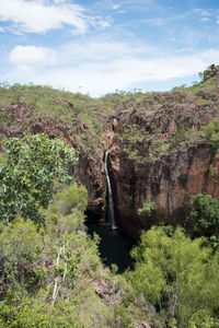 Scenic view of waterfall against sky