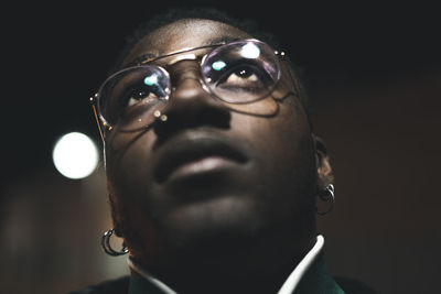 Close-up of thoughtful young man looking away at night