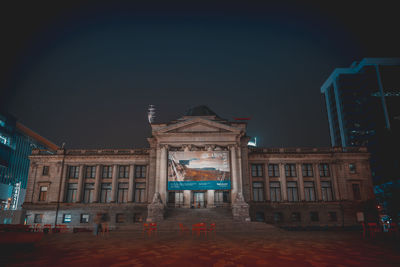 Low angle view of illuminated building against sky at night