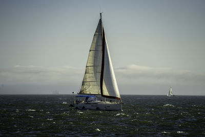 Sailboat sailing on hudson river against sky during sunset