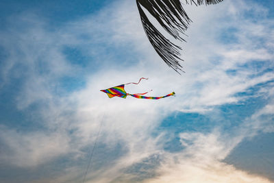 Low angle view of kites flying against sky