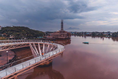 View of bridge over water against cloudy sky