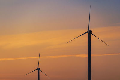 Low angle view of silhouette wind turbine against sky during sunset