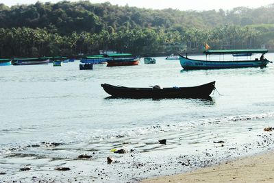 Boats in lake against trees