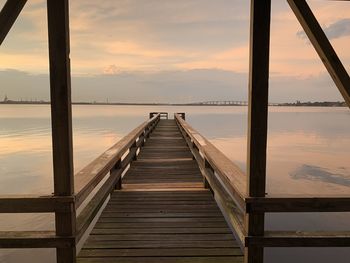 Pier over sea against sky during sunset