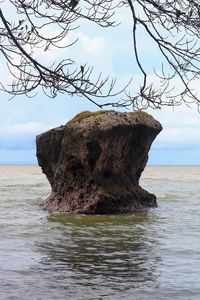 Scenic view of rocks in sea against sky