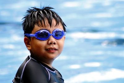 Portrait of smiling boy wearing swimming goggles in pool
