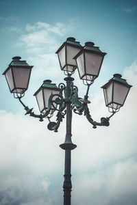 Low angle view of illuminated street light against sky