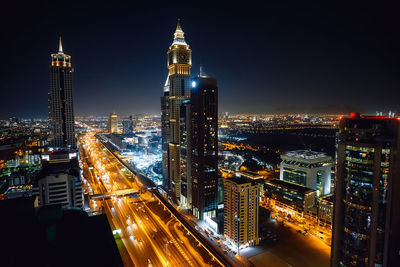 Illuminated buildings in city against sky at night