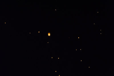 Low angle view of illuminated lights against sky at night