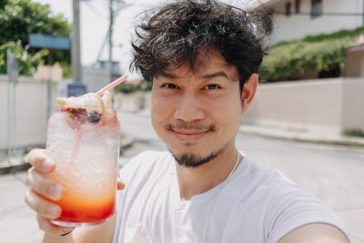 Portrait of smiling man holding drink