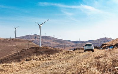 Wind turbines on desert against sky