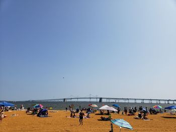 People on beach against clear sky