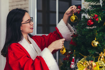 Woman holding christmas tree at home