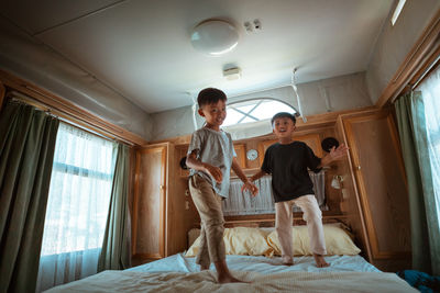 Young woman sitting on bed at home
