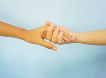 Close-up of hands consoling on blue background