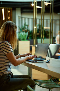 Woman using laptop in coworking. female freelancer typing on laptop keyboard. online work in cafe