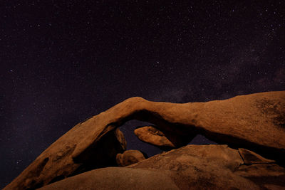 Low angle view of rock against sky at night