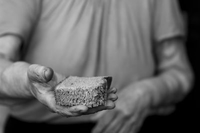 Midsection of man holding slice of cake