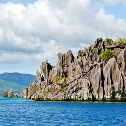 Rock formations by sea against sky