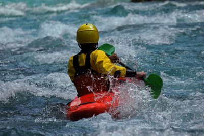 Rear view of person surfing in water