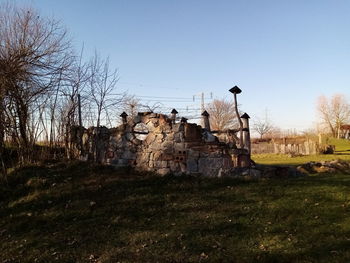 Abandoned building on field against clear sky