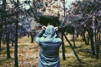 Rear view of man standing at forest