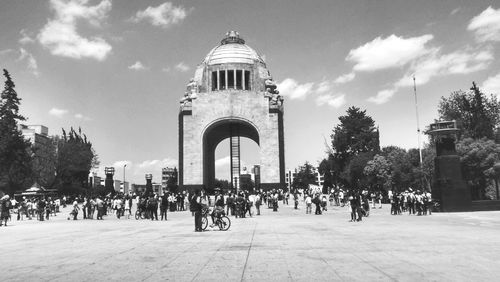 Tourists against cloudy sky