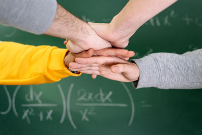 Cropped image of people stacking hands