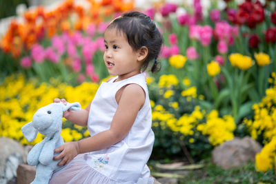 Cute little girl standing at flower garden thailand.