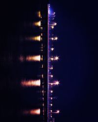 Low angle view of illuminated lights against sky at night