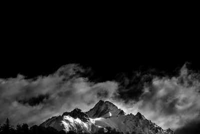 Low angle view of snowcapped mountains against sky