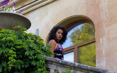 Woman looking away while standing against building