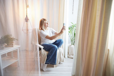 Rear view of woman looking through window