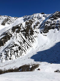 Scenic view of snow covered mountains against clear sky