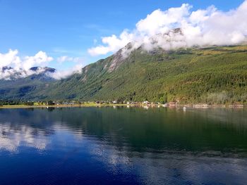 Scenic view of lake by mountains against sky