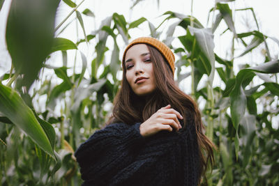 Portrait of young woman against plants