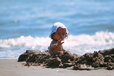 Portrait of young woman standing at beach